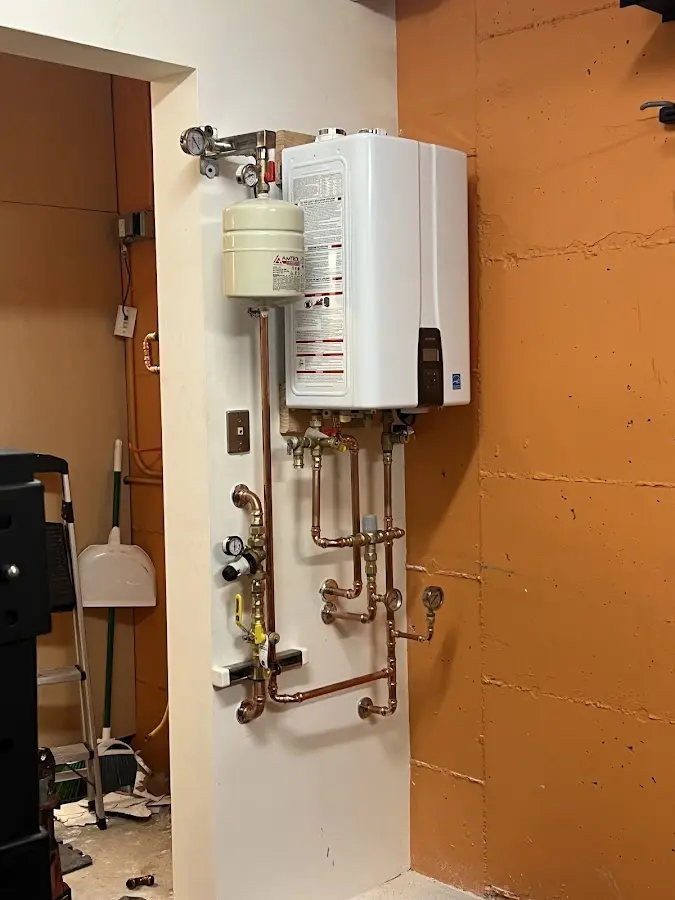Plumbing technician inspecting water heater connections in Millbrook